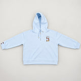 Baby blue hooded sweatshirt laid flat, showing drawcords and the pups embroidery