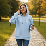 Sky blue half zip hoodie worn with jeans on an autumn park path, coffee in hand