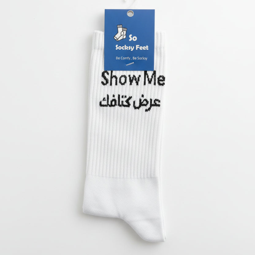 White crew socks knitted with Show Me above a line of black Arabic lettering