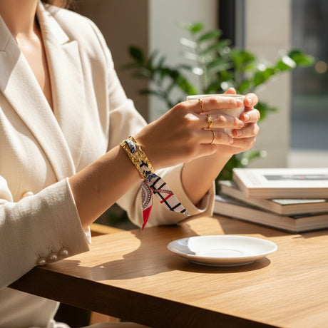 Silk scarf bangle bracelet with a colorful pattern on a wrist in a living room setting