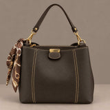 Dark brown top handle bag with contrast stitching and a brown chain print scarf