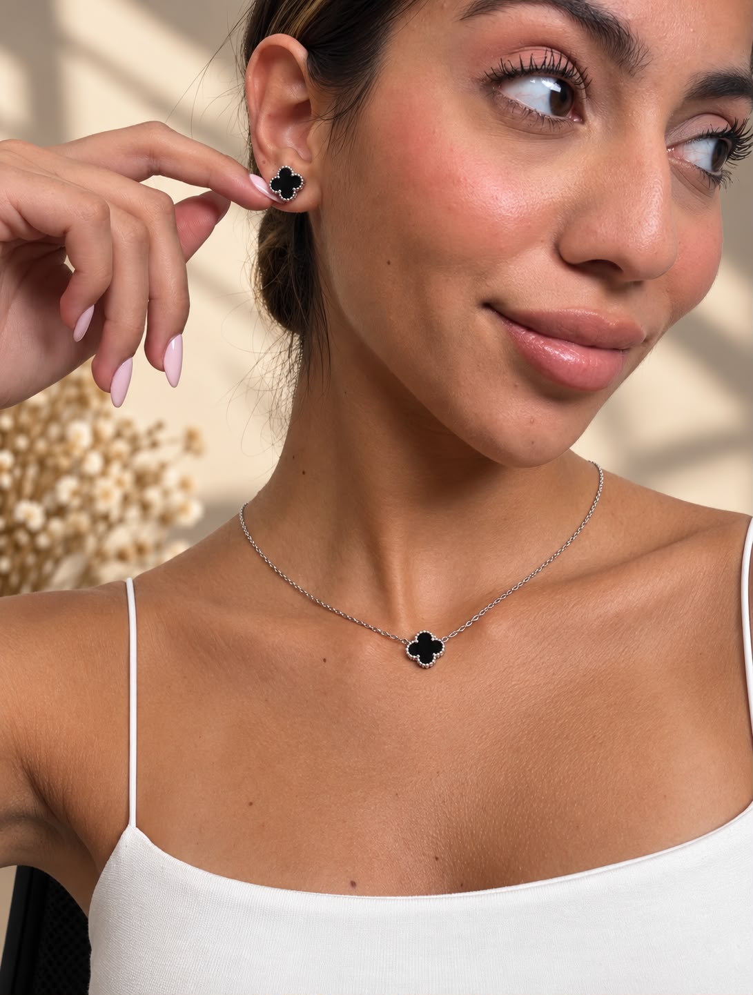 Black clover stud earring and matching pendant necklace worn with a white cami