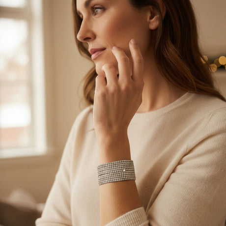 Woman wearing a silver bracelet, sitting indoors with a blurred background