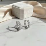 Silver crystal hoop earrings on a marble surface