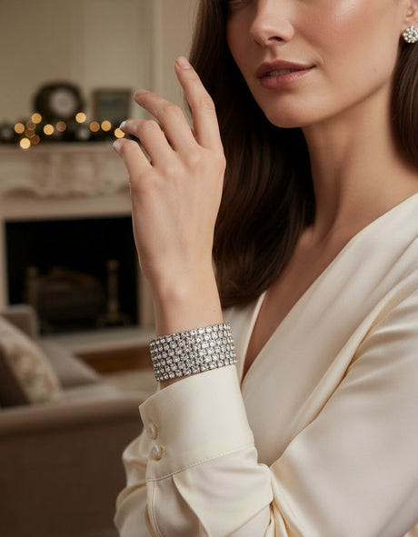 Woman wearing a white dress with a close-up of her hand and silver bracelet in a warm indoor setting