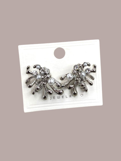 Pair of silver modern earrings with pearls on a jewelry card against a beige background