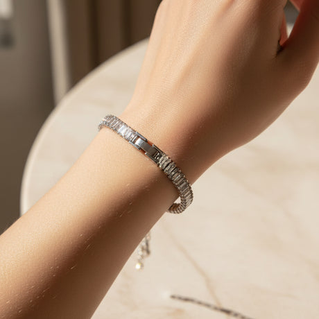 Silver baguette tennis bracelet with clear stones on a person's hand