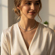 Woman wearing a silver tennis choker in a softly lit setting