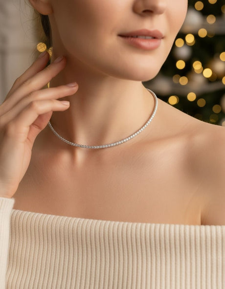 Woman wearing a silver necklace with blurred lights in the background