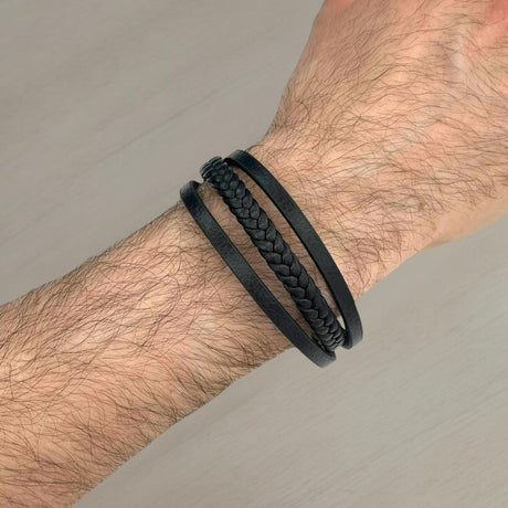 Close-up of a wrist wearing a 4-strand leather bracelet on a neutral background