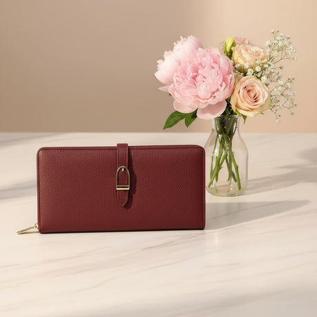 Red wallet on a light surface with a vase of flowers in the background