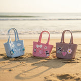 Baby blue, bubblegum pink and mauve EVA beach totes lined up on sand with charm decorations