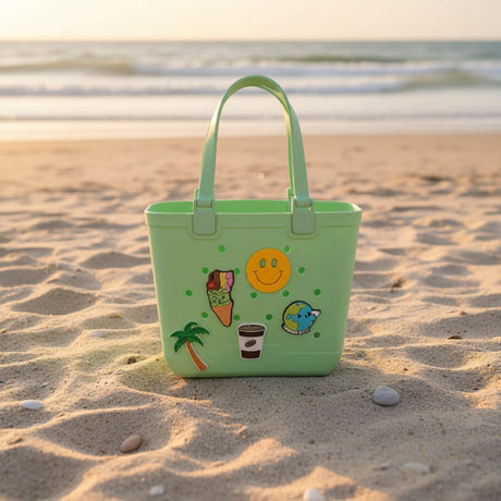 Mint green kids tote with smiley face, ice cream, palm tree, coffee cup and globe charms on soft sand