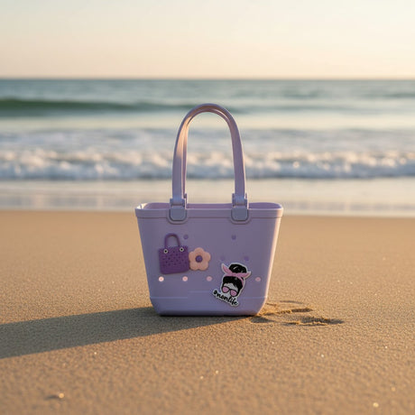 Lilac rubber beach tote with purple handbag, blossom and sunglasses girl charms on golden sunset sand