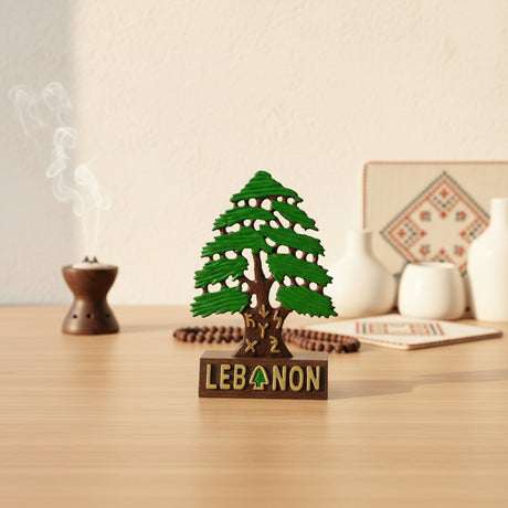 Wide spreading cedar tree statue with layered green foliage on a wooden Lebanon base