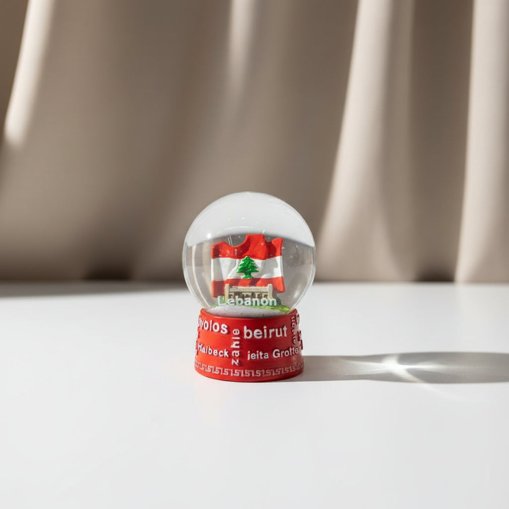 Snow globe with a waving Lebanese flag inside, on a red base printed with city names