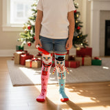 Child standing by a Christmas tree in pink and blue snowman knee high socks