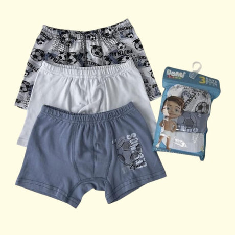 Three boys boxer shorts in blue, white and football print beside the retail pack