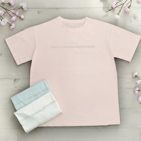 Pink t-shirt with small text on a light wooden background