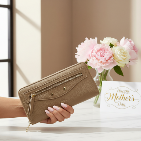 Hand holding a brown wallet with flowers and a Mother's Day card in the background