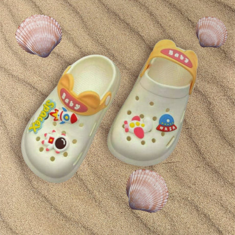 Kids cream clogs with rocket and astronaut charms and an orange strap