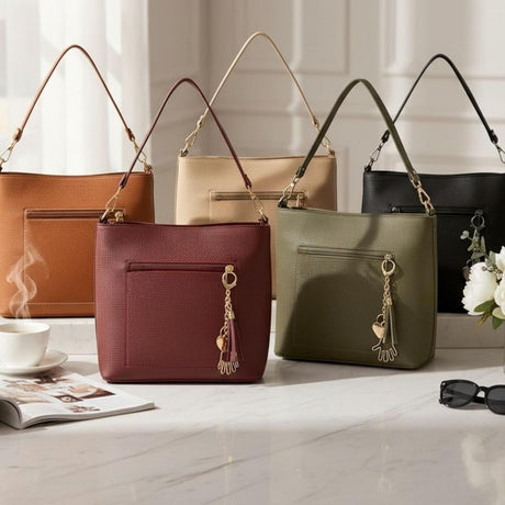 Five shoulder bags grouped on marble in tan, cream, burgundy, olive and black