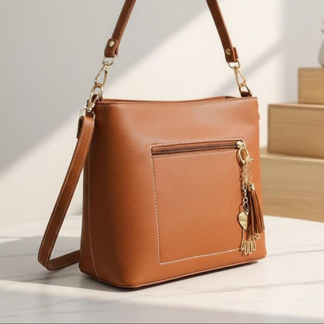 Tan bag in sunlight showing the top handle, detachable strap and stitched side panel