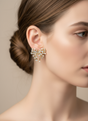 Close-up of a woman wearing a sparkly bow earring against a neutral background