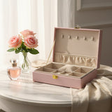 Pink glitter jewelry box open with a cream lined tray, elastic pocket and ring cushion