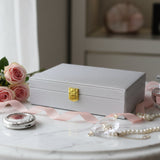 Silver glitter jewelry box shown at an angle with a chunky gold push lock clasp