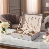 White glitter jewelry box open with gold chains and rings laid in its compartments