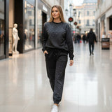 Woman in a sparkly sweatshirt and pants walking through a shopping mall