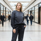 Woman in a black outfit with sparkly star patterns standing in a shopping mall
