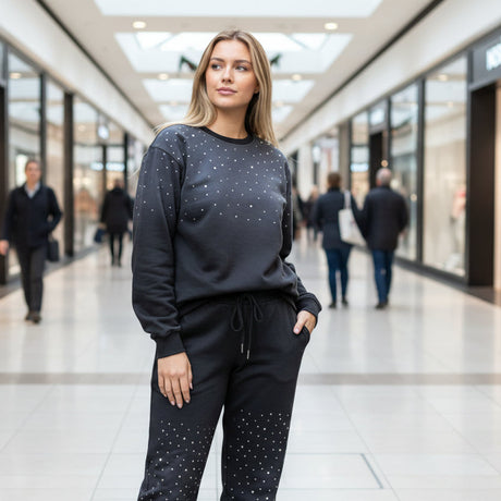 Woman in a black outfit with sparkly star patterns standing in a shopping mall