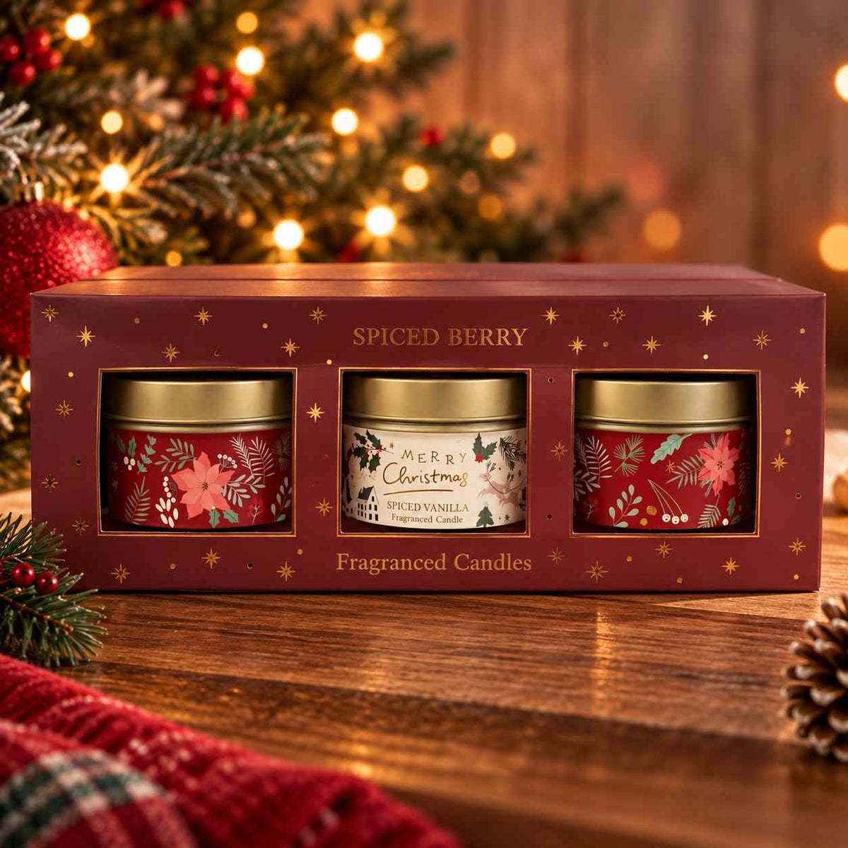 Three Spiced Berry scented tin candles with gold lids in a burgundy Christmas window box