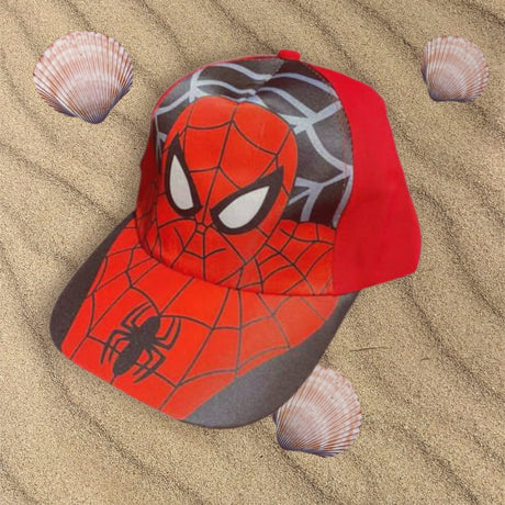 Red and grey childrens cap with a spider emblem and web design on the peak, resting on sand