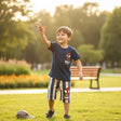 Child playing with a toy airplane in a park wearming spider man