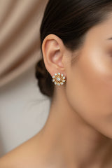 Close-up of a woman wearing a decorative circle earring with a neutral background