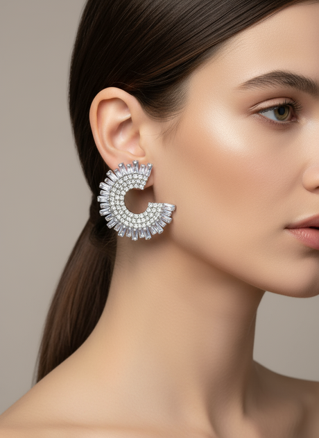 Close-up of a woman wearing a sparkling silver earring against a neutral background