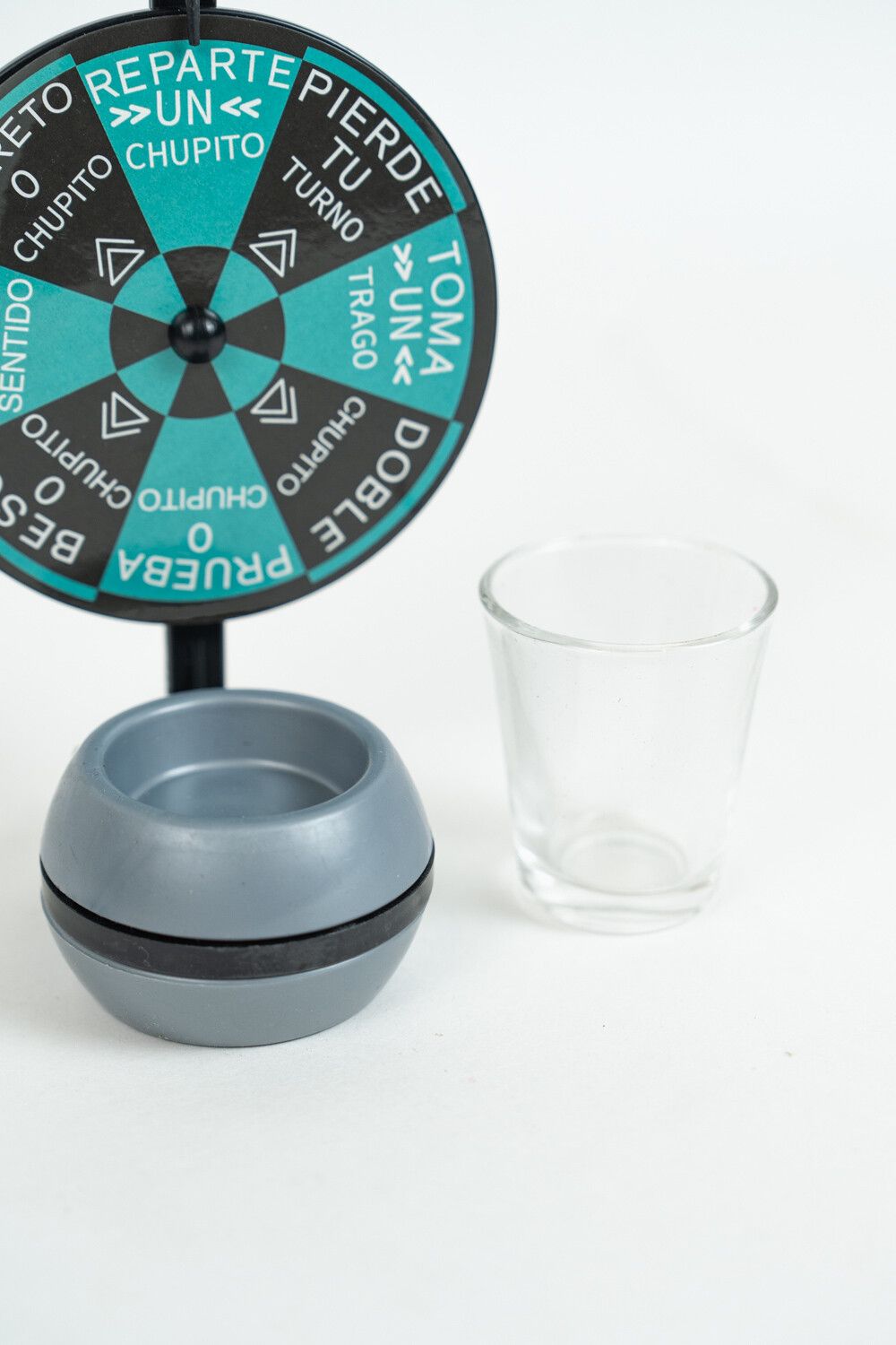 Weighted dome base with its rotating band and cup recess, beside a clear shot glass