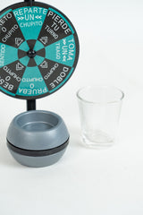 Weighted dome base with its rotating band and cup recess, beside a clear shot glass
