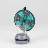 Spinning dare wheel in teal and charcoal on a post above a weighted base and shot glass