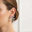 Close-up of a woman wearing a splash earring against a neutral background