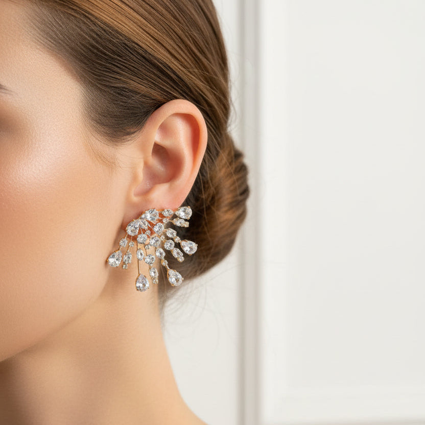 Close-up of a woman wearing a splash earring against a neutral background