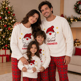 Close up of parents and two kids posing together in matching Santa fleece pyjama sets