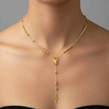 Gold St Charbel necklace with a cross pendant on a model against a neutral background