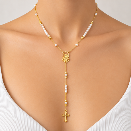 Pearl and gold bead rosary necklace with a small saint medal and cross, worn with a white top