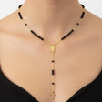 Black beaded St Charbel necklace with gold accents worn by a woman