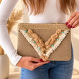 Beige jute clutch bag with a V shaped fringe of pom poms, turquoise discs and a gold star