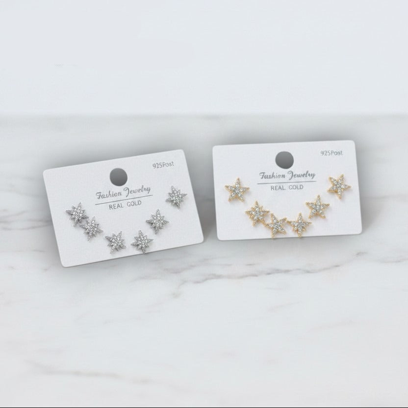 Pair of star stud earring sets on display cards with branding on a marble surface